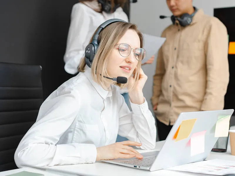 A support specialist with a headset working at a laptop